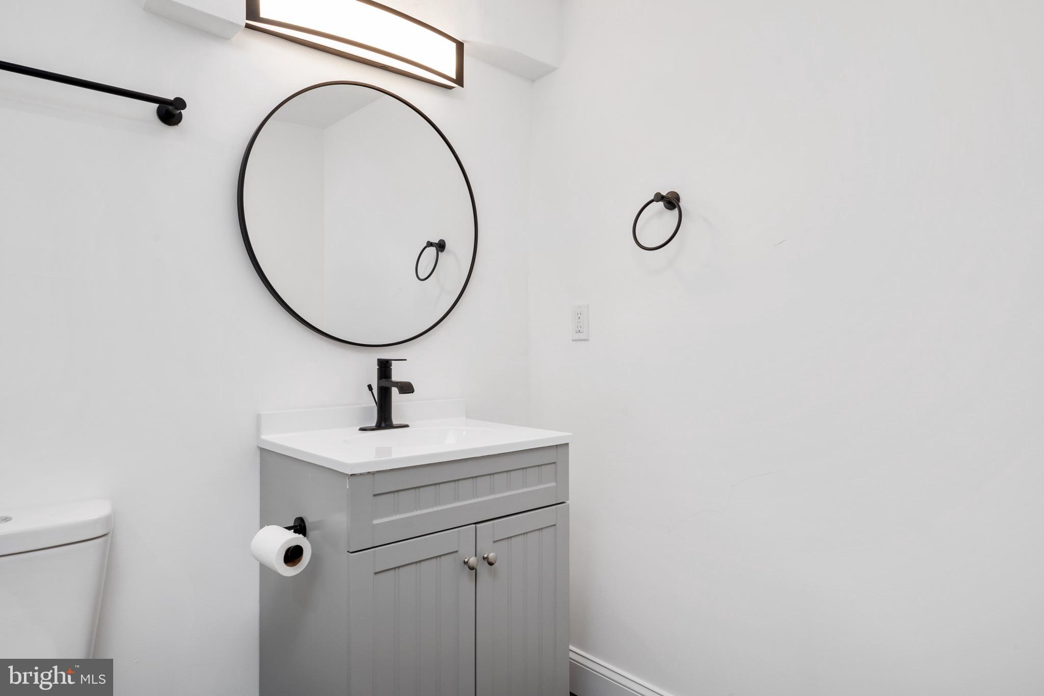2828 Lake Avenue Baltimore, MD 21213 - Photo 21 of 28 a bathroom with a sink a mirror and a shower