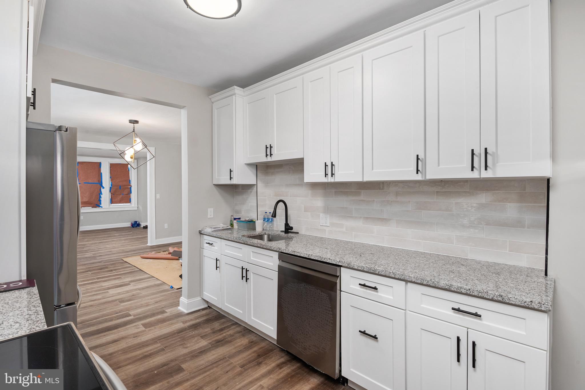 2828 Lake Avenue Baltimore, MD 21213 - Photo 8 of 28 a kitchen with granite countertop white cabinets and white appliances