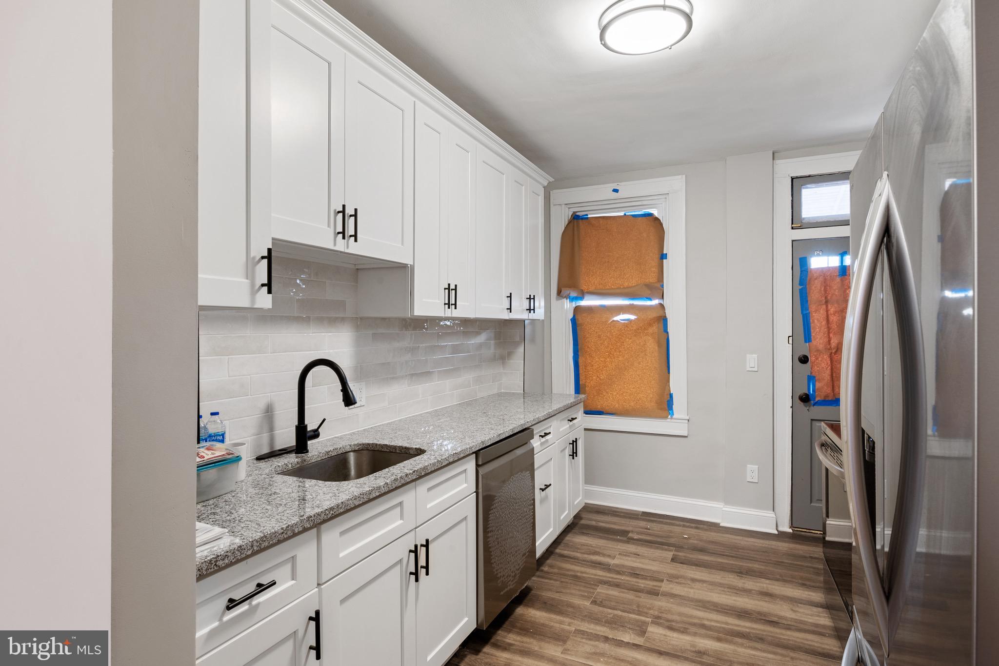 2828 Lake Avenue Baltimore, MD 21213 - Photo 9 of 28 a kitchen with stainless steel appliances granite countertop a sink and a refrigerator