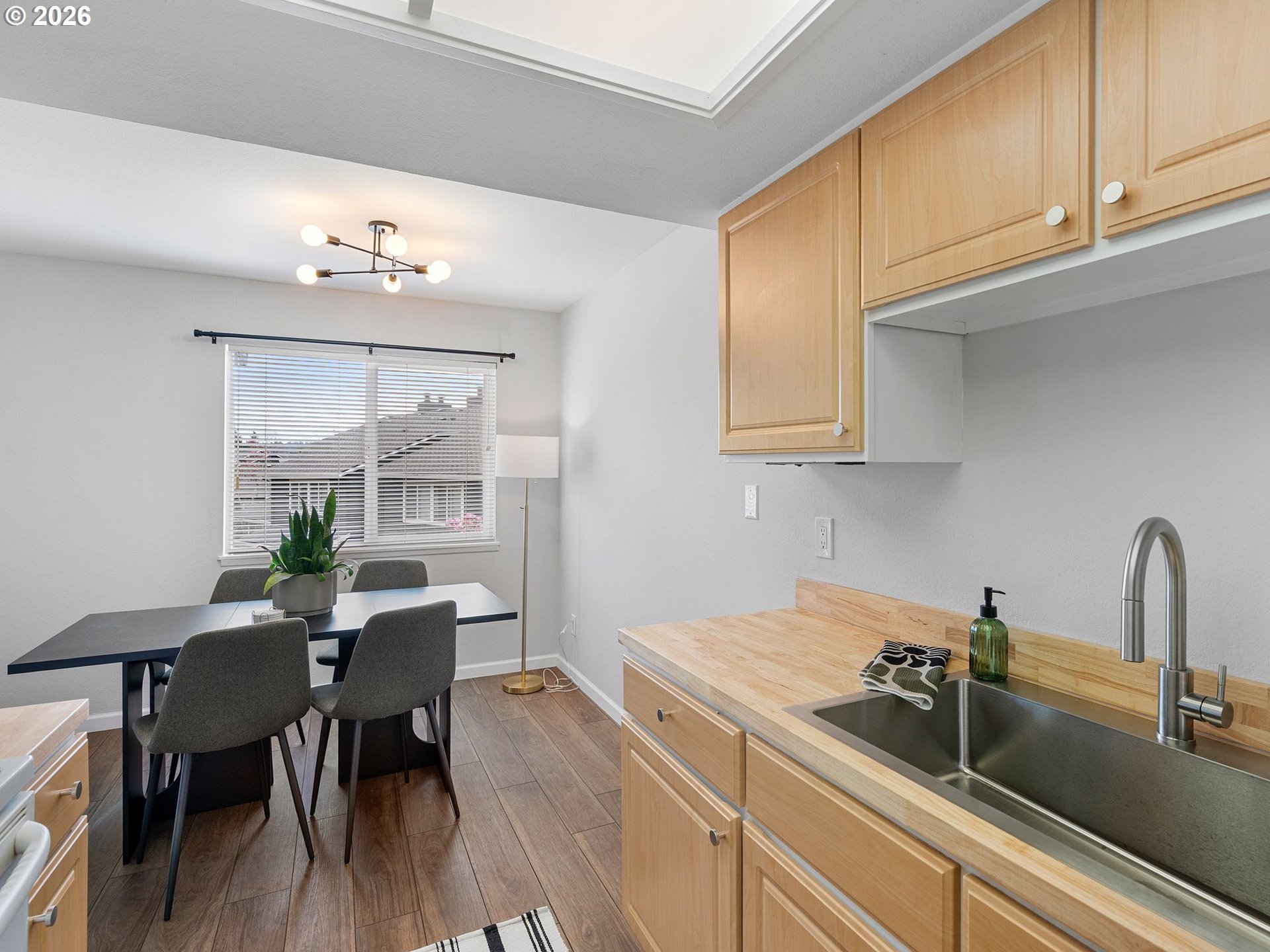 9370 Southwest 146th Terrace, Unit N5 Beaverton, OR 97007 - Photo 12 of 35 a kitchen with a sink cabinets and dining table
