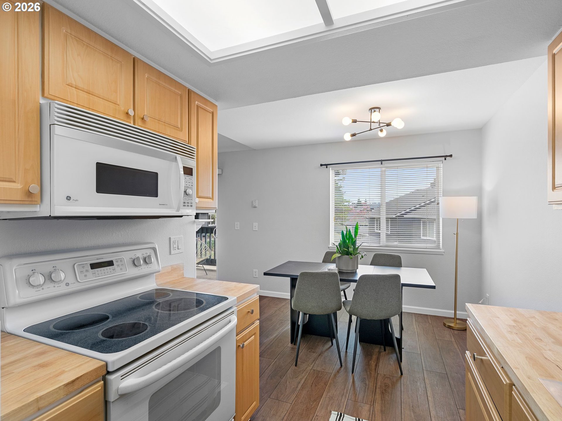 9370 Southwest 146th Terrace, Unit N5 Beaverton, OR 97007 - Photo 13 of 35 a kitchen with a stove cabinets and dining table