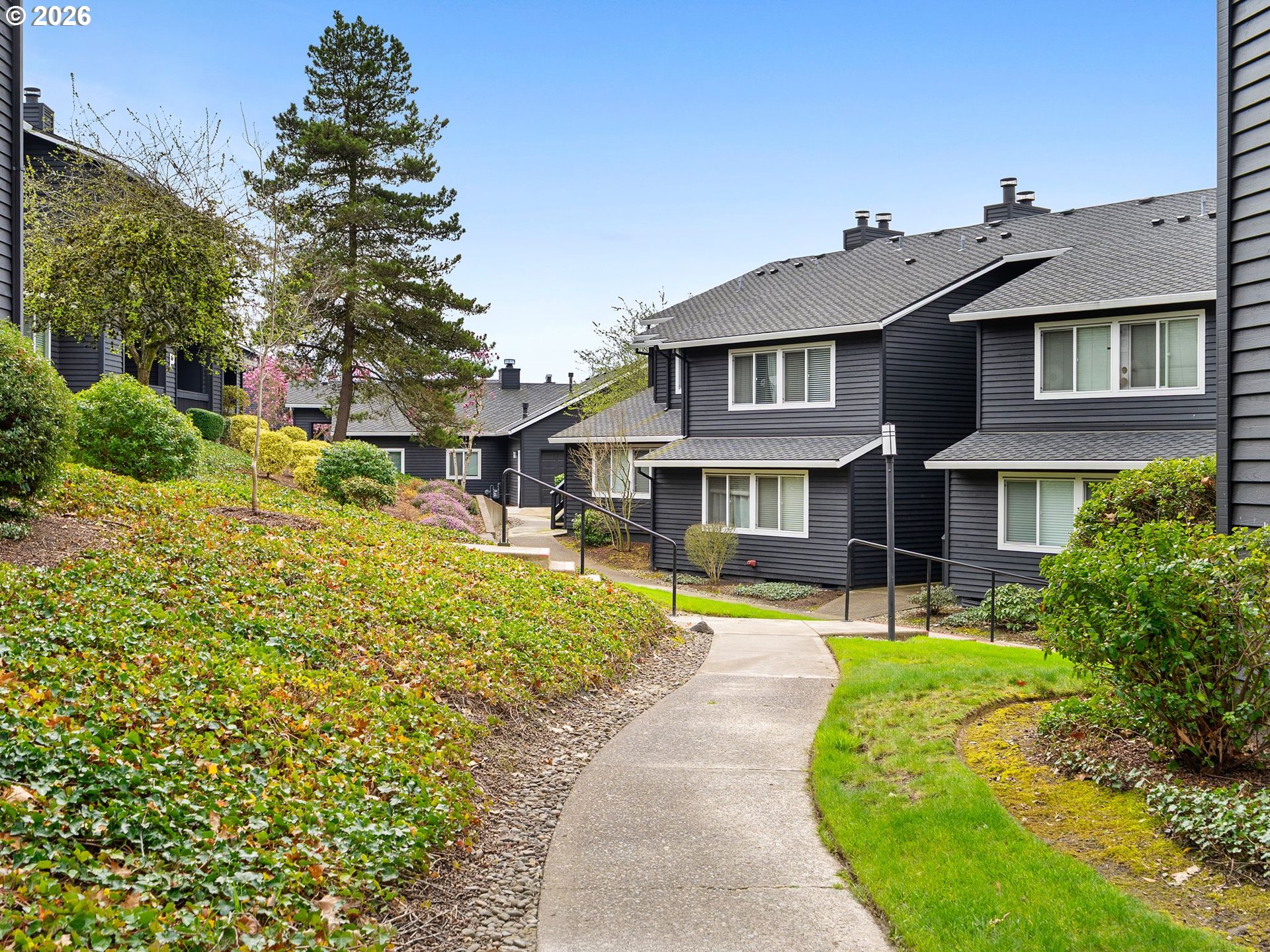 9370 Southwest 146th Terrace, Unit N5 Beaverton, OR 97007 - Photo 26 of 35 a front view of a house with a yard table and chairs