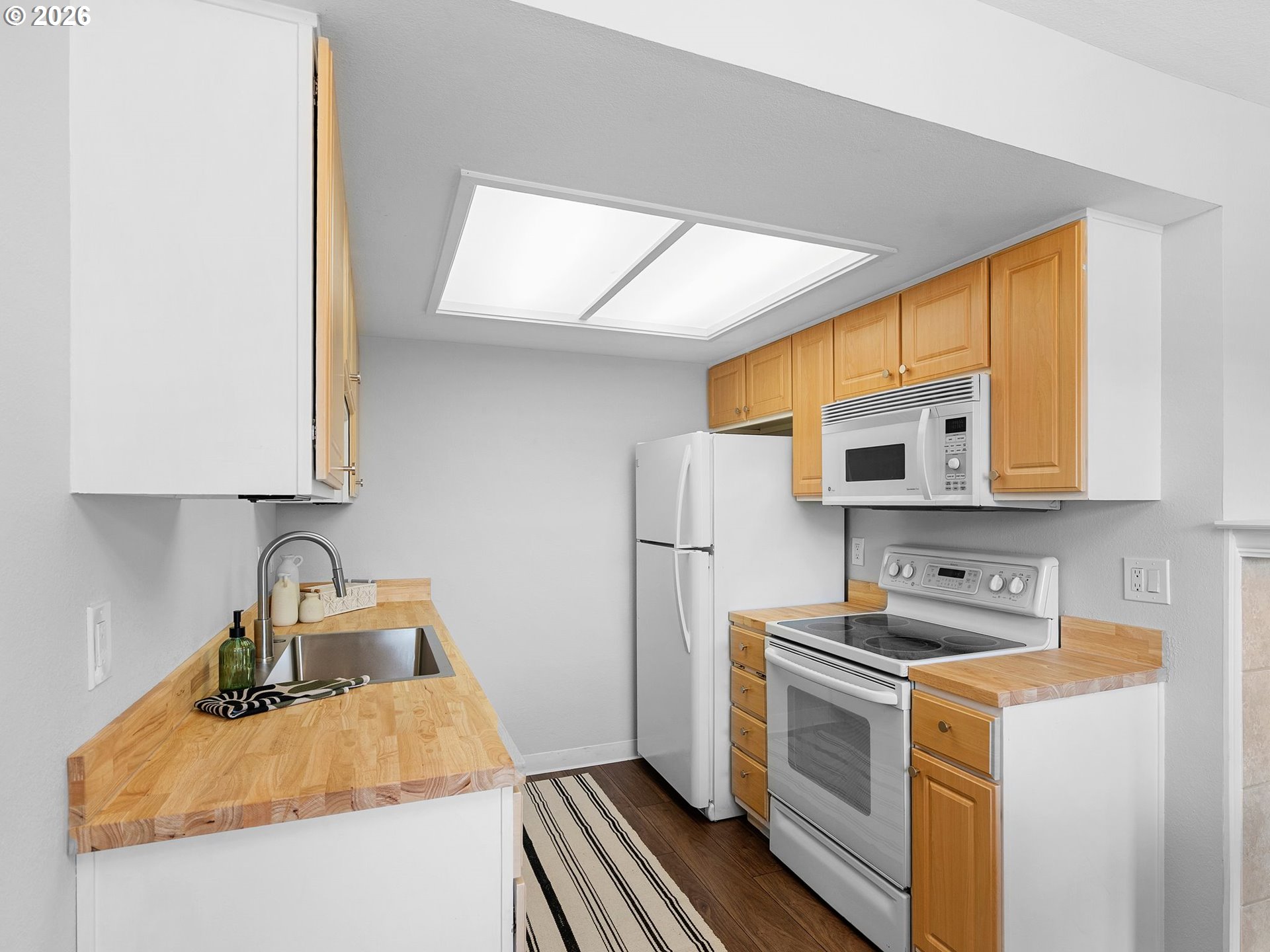 9370 Southwest 146th Terrace, Unit N5 Beaverton, OR 97007 - Photo 10 of 35 a kitchen with stainless steel appliances granite countertop a sink stove and refrigerator