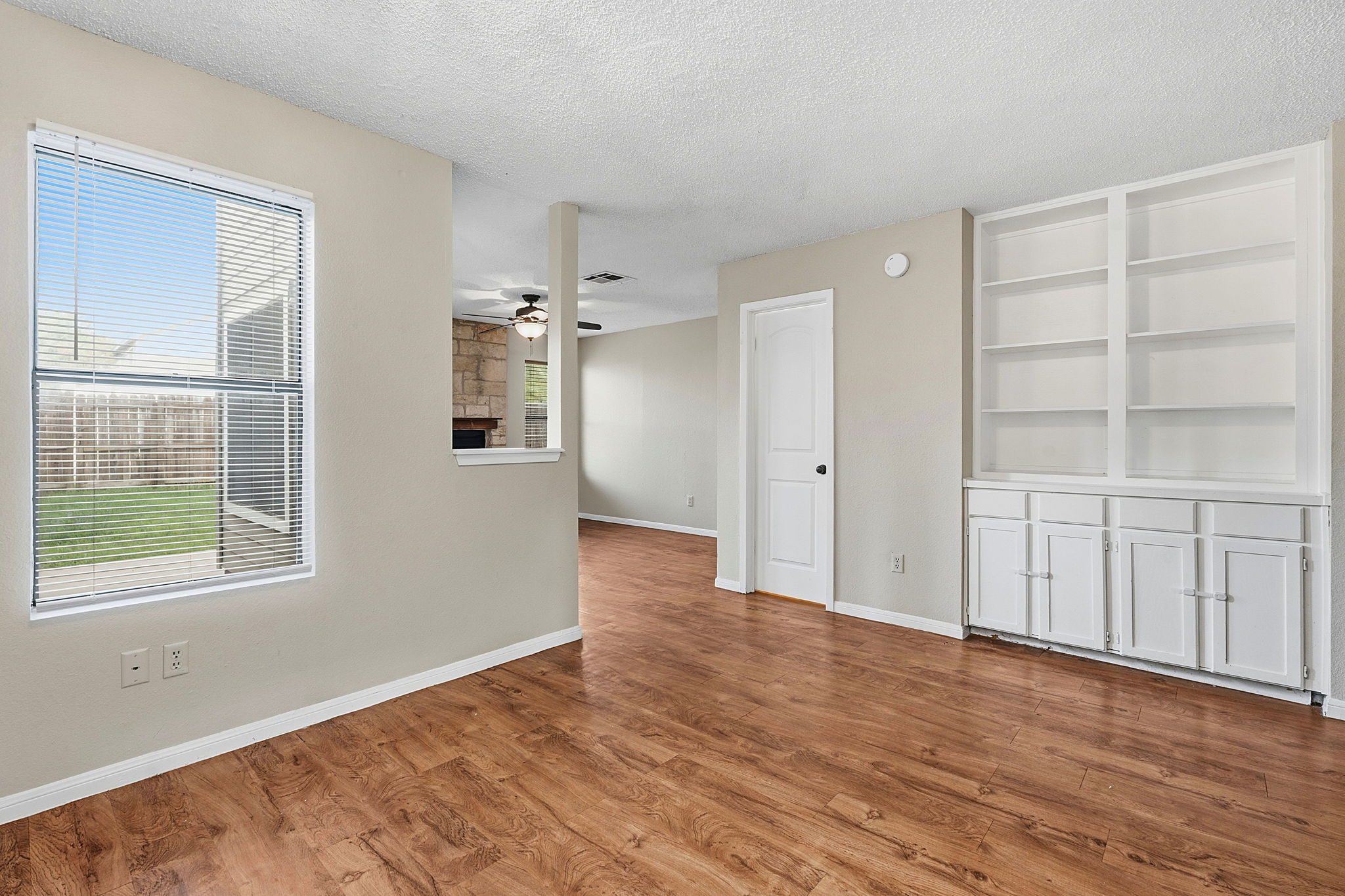 8811 Schick Road Austin, TX 78729 - Photo 8 of 27 Rich hardwood-style flooring extends through this airy living space with built-in shelving.