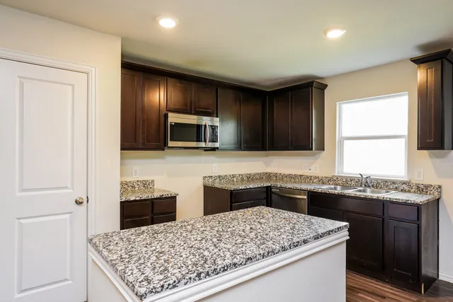 a kitchen with a sink stove and refrigerator