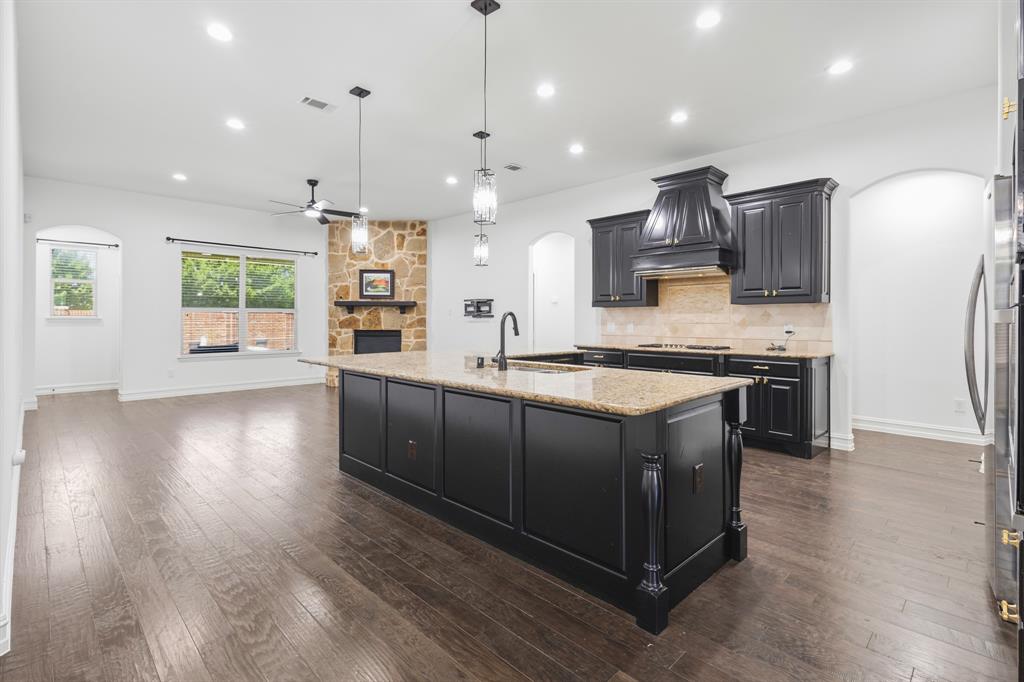 1995 Verde Court Allen, TX 75013 - Photo 21 of 30 Kitchen island featuring a granite countertop and integrated sink