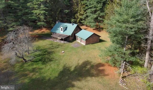 an aerial view of a house with backyard space and tree