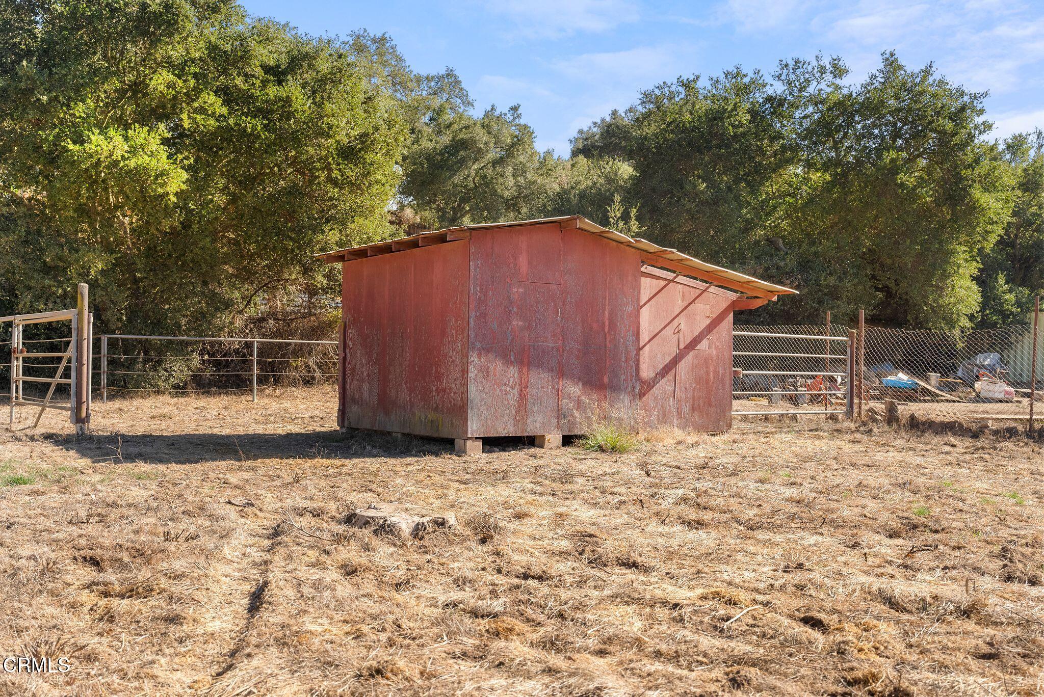 830 South Rice Road Ojai, CA 93023 - Photo 5 of 39 a backyard of a house with large trees and a wooden fence