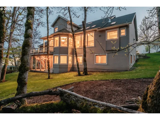 a view of an house with backyard and trees
