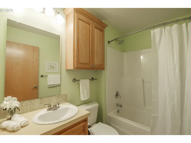 a bathroom with a sink shower and a mirror