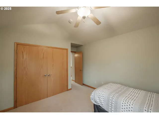 a bedroom with a bed and a chandelier fan