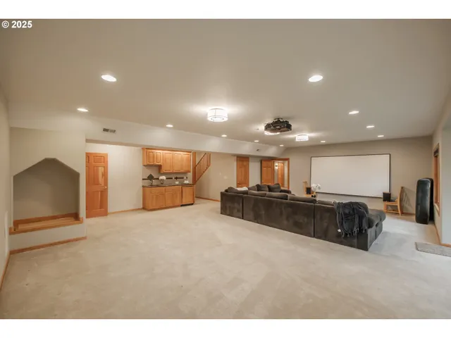 a large living room with stainless steel appliances lots of white furniture