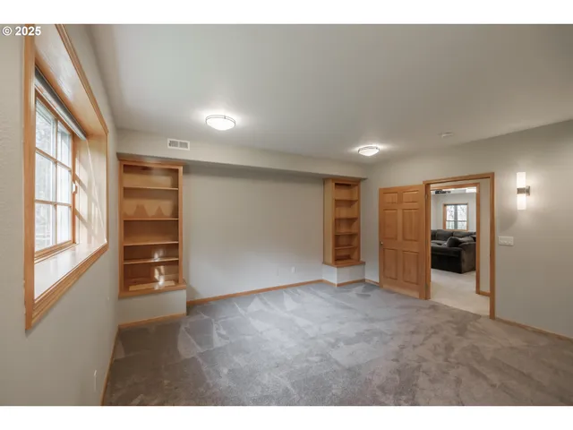 a view of empty room with wooden floor and window