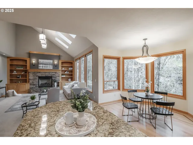 a living room with furniture a fireplace and large windows