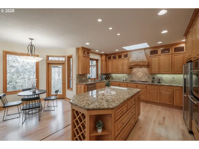 a kitchen with stainless steel appliances granite countertop a kitchen island a stove and a sink