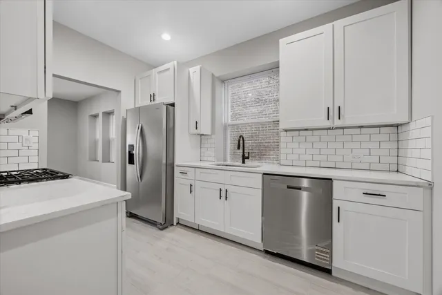 a kitchen with stainless steel appliances granite countertop a stove a sink and a refrigerator