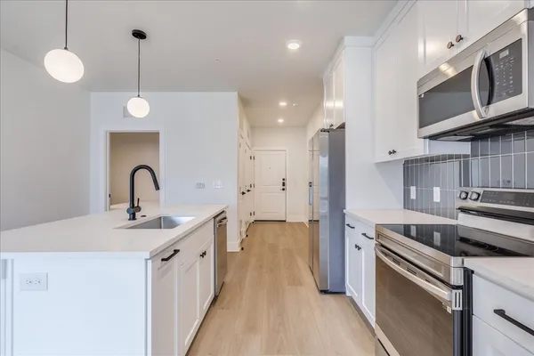a kitchen with stainless steel appliances a refrigerator sink and stove