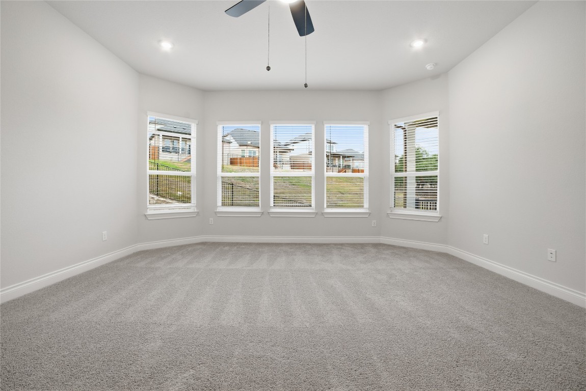 716 Coppell Court Leander, TX 78641 - Photo 16 of 40 an empty room with windows and ceiling fan