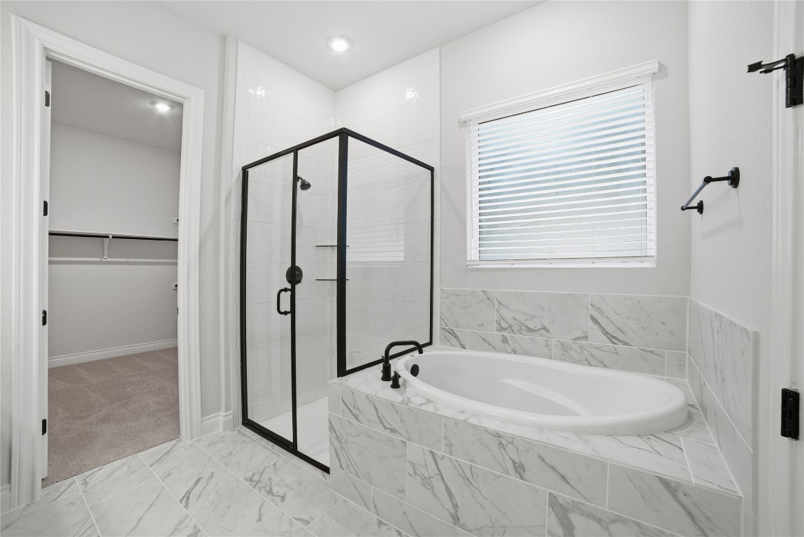 716 Coppell Court Leander, TX 78641 - Photo 27 of 40 a spacious bathroom with a tub shower and a mirror