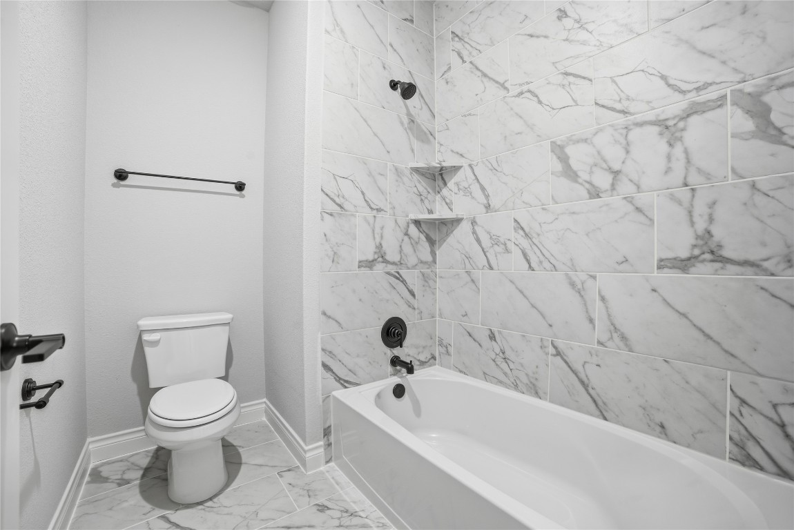 716 Coppell Court Leander, TX 78641 - Photo 30 of 40 a bathroom with a toilet and a tub