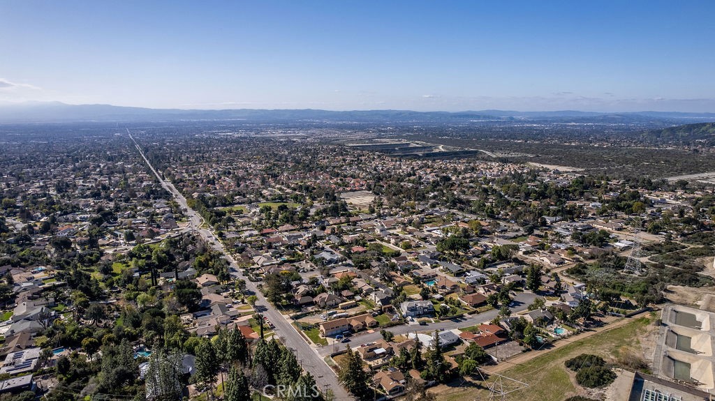 an aerial view of house with yard and mountain view in back