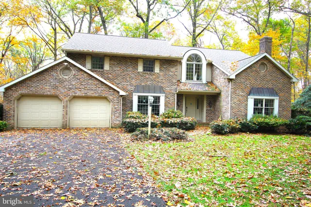 a front view of a house with yard and green space