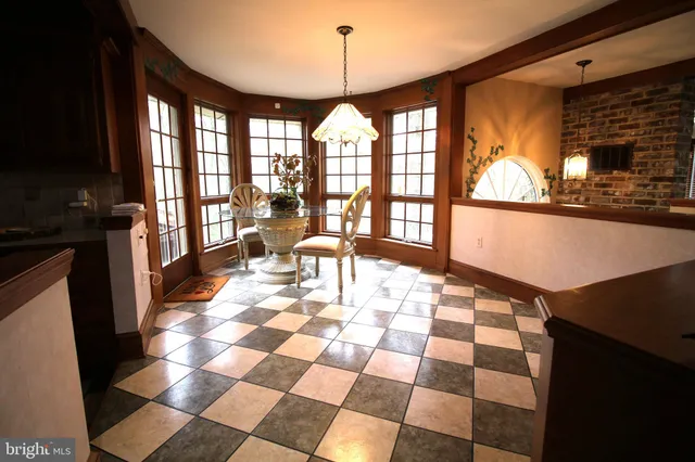 a dining hall with stainless steel appliances granite countertop a stove a sink a dining table and chairs