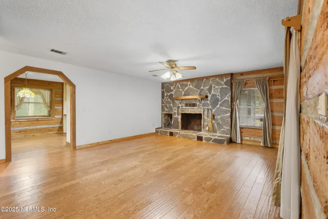 a view of an empty room with a fireplace and a window