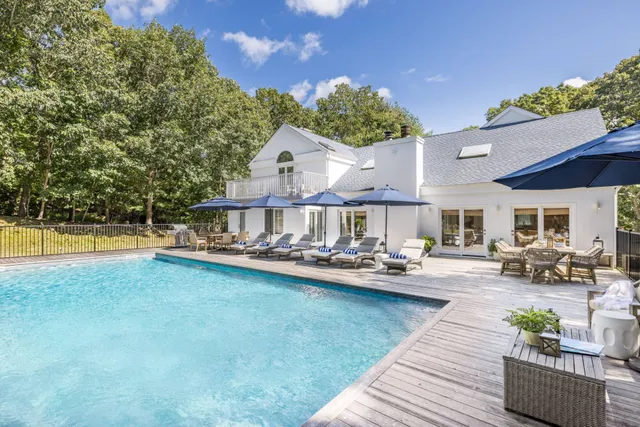 a view of a house with swimming pool and sitting area
