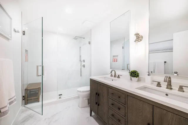 a bathroom with a double vanity sink mirror double and shower