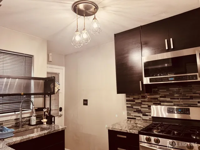 a kitchen with stainless steel appliances granite countertop a stove and a microwave