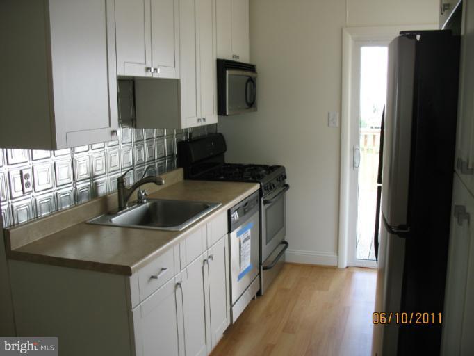 4215 Ivy Glen Road Silver Spring, MD 20906 - Photo 4 of 8 a kitchen with a sink stove and refrigerator