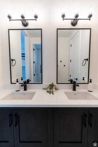 5355 Cyan Lane St. George, UT 84790 - Photo 32 of 39 Dual vanity with integrated sinks, white countertops, matte black hardware, dark wood-finish cabinetry, and framed mirrors