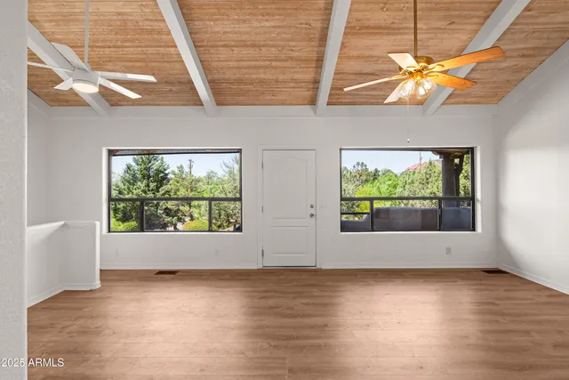 a view of an empty room with a window and fireplace