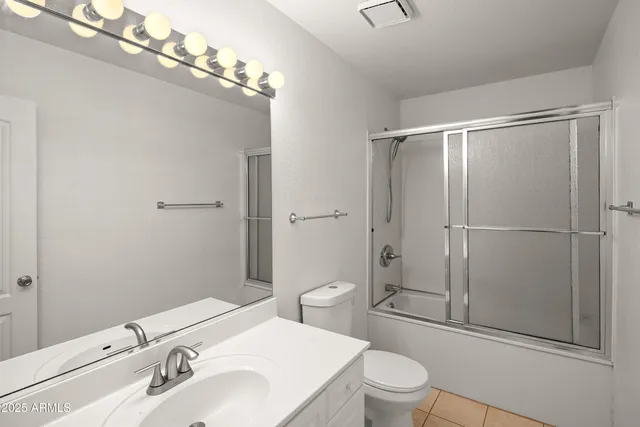 a view of an empty room with wooden floor and closet