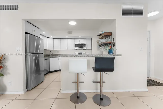 a kitchen with stainless steel appliances granite countertop a refrigerator and a stove top oven