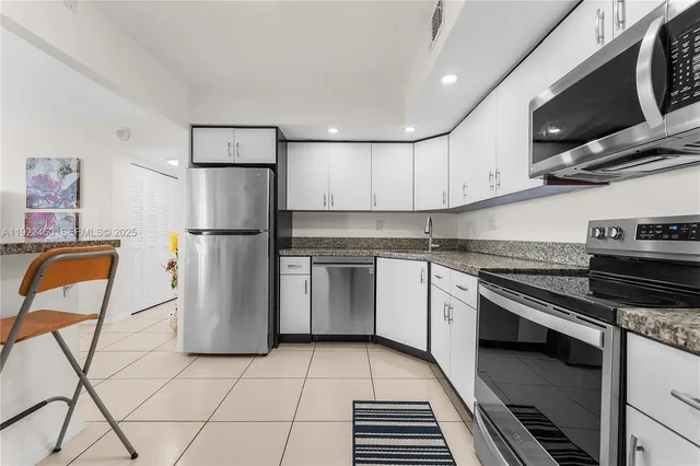 a kitchen with stainless steel appliances granite countertop a refrigerator and a stove top oven