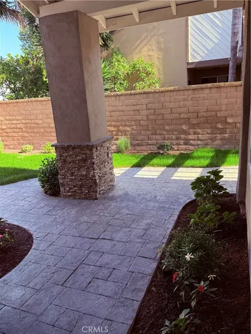 a view of a backyard with plants and a patio