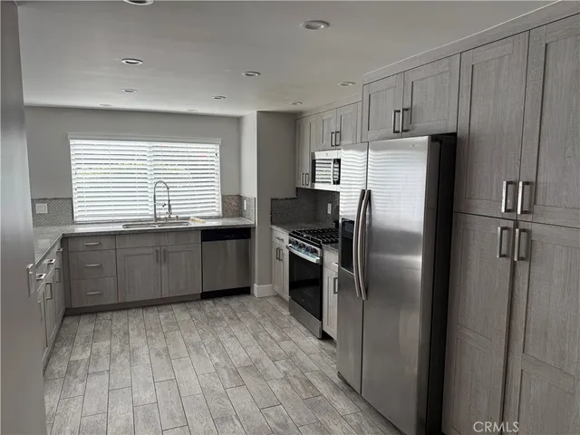 a kitchen with granite countertop a refrigerator and a sink