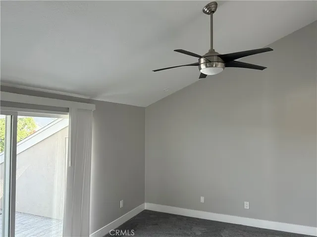 a view of a room with a balcony and ceiling fan