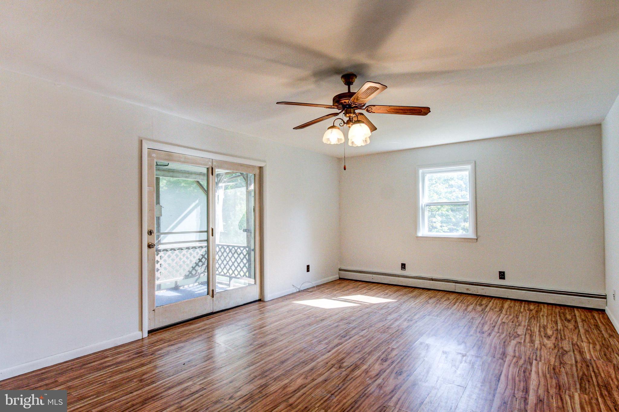 2030 Upper Ridge Road Green Lane, PA 18054 - Photo 17 of 61 an empty room with wooden floor chandelier fan and windows