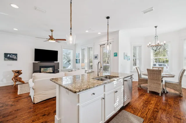 a dining room with furniture a chandelier and wooden floor
