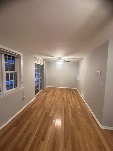 a view of empty room with wooden floor and windows