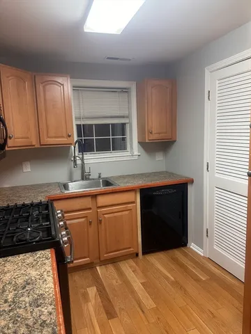 a kitchen with granite countertop a stove a sink and a microwave