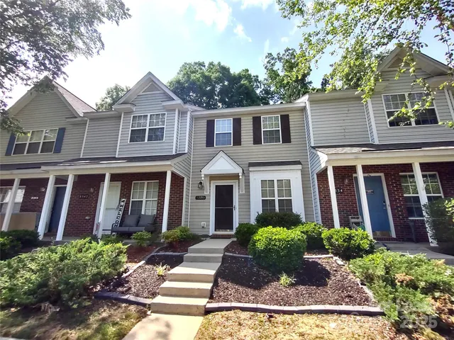 front view of a brick house with a yard