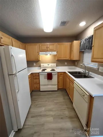 a kitchen with a sink a refrigerator and a stove