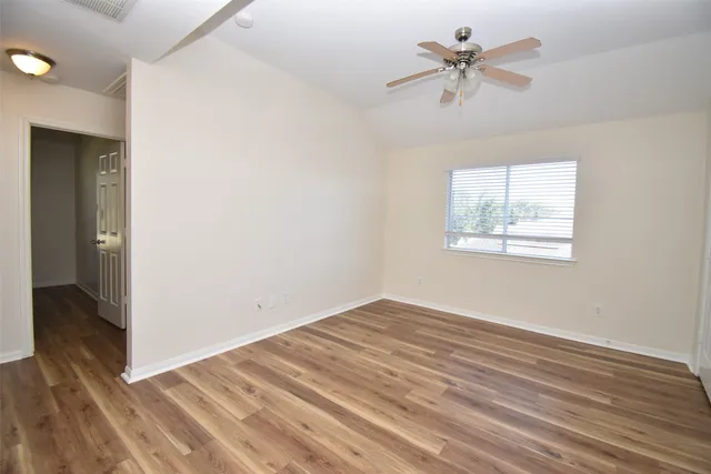 an empty room with fan and windows