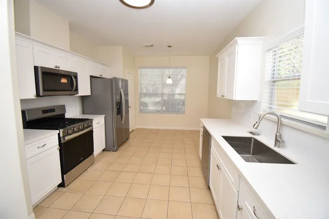 a kitchen with a sink a stove top oven and refrigerator
