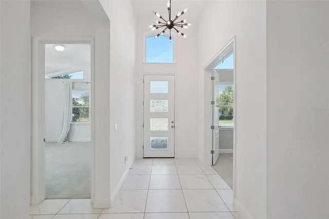 a view of a hallway with a chandelier fan and windows