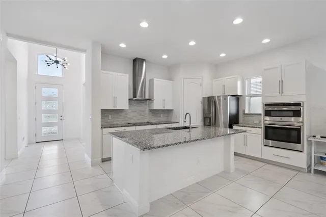 a large kitchen with a large counter top stainless steel appliances and cabinets